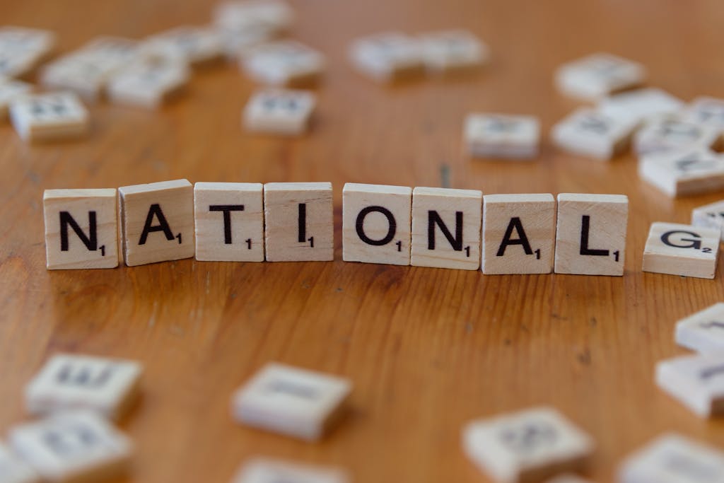 Wooden letter tiles spell 'National' on a wooden table.
